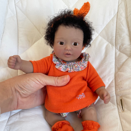 Moly, a girl with black afro hair, brown eyes, and dark skin.